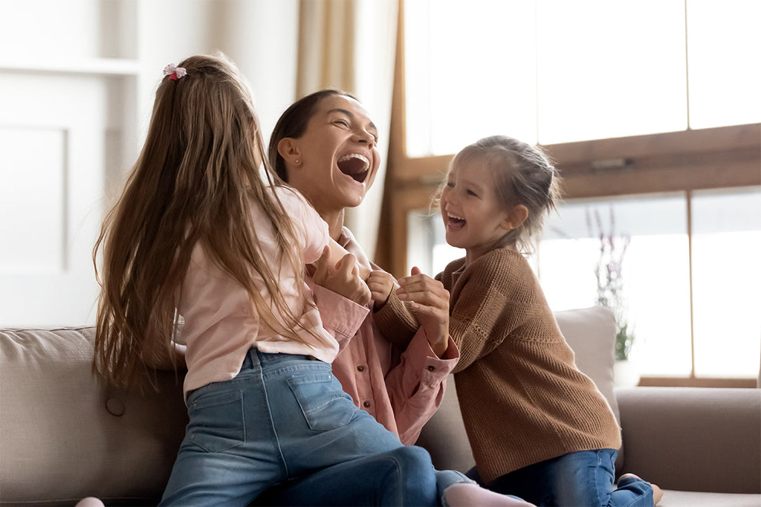 mom and two kids laughing on the couch