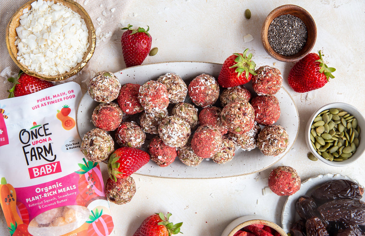 butternut squash strawberry energy bites on a tray, next to the Once Upon a Farm Plant-Rich Meal package and various ingredients