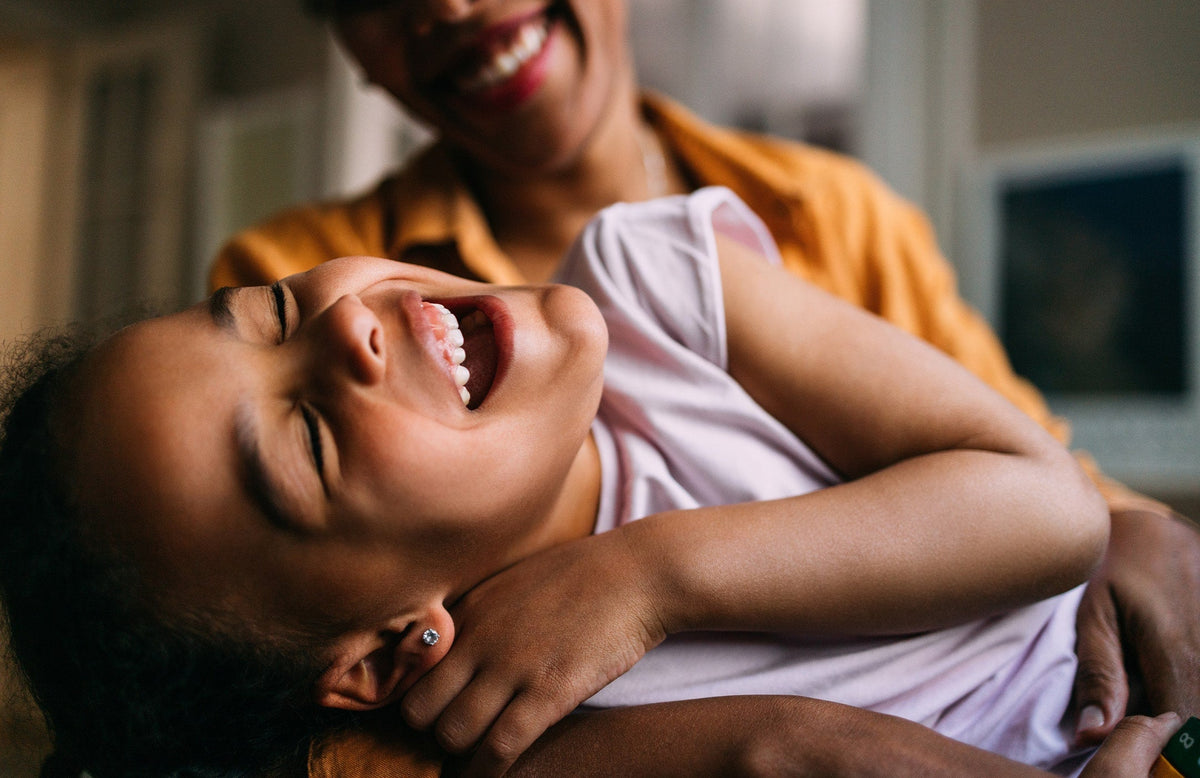 child laughing with mom