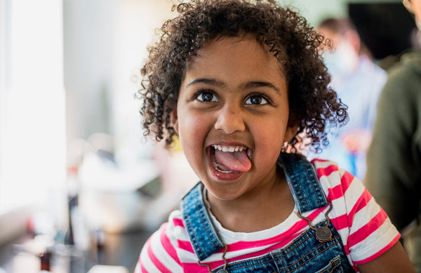 young child playfully sticking their tongue out