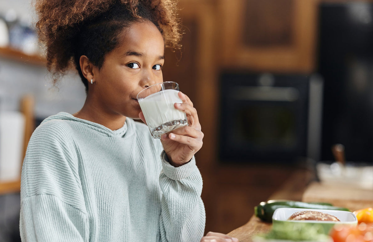 adolescent girl drinking a glass of milk