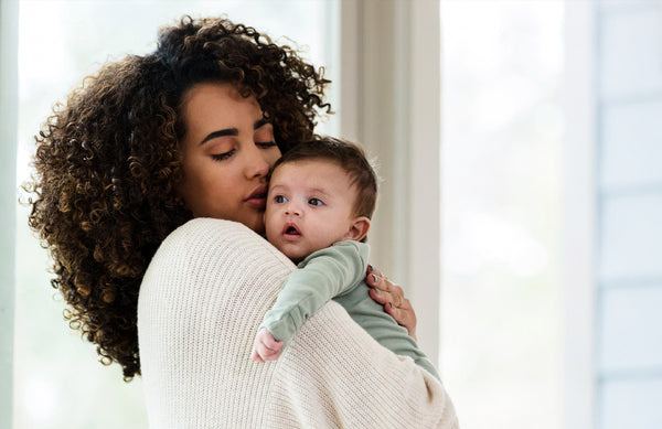close-up of mom holding a baby and comforting them